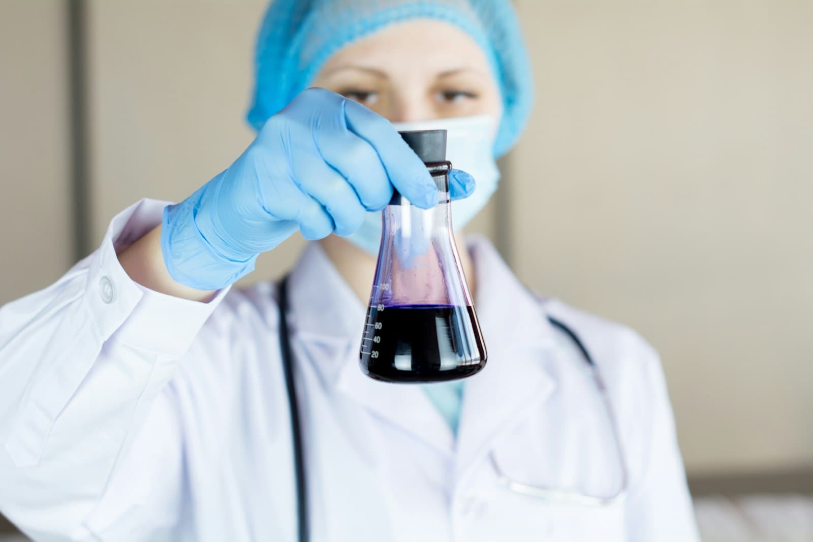 A researcher in a lab coat holding a flask